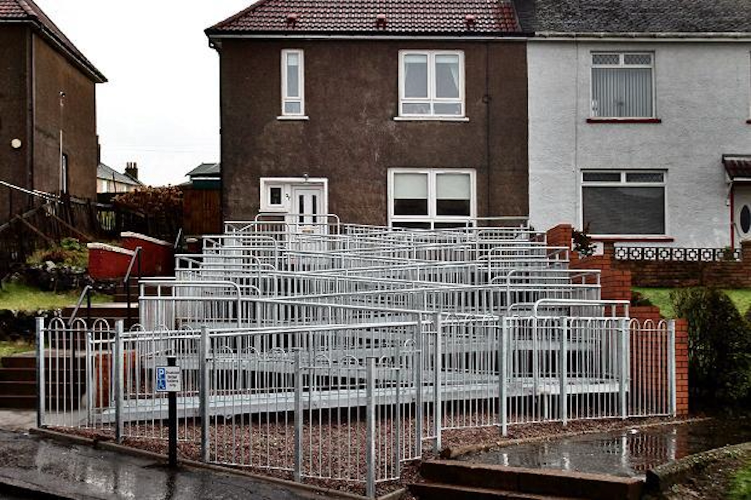 A house with a ramp zigzagging more than seven times up its yard to the front door.