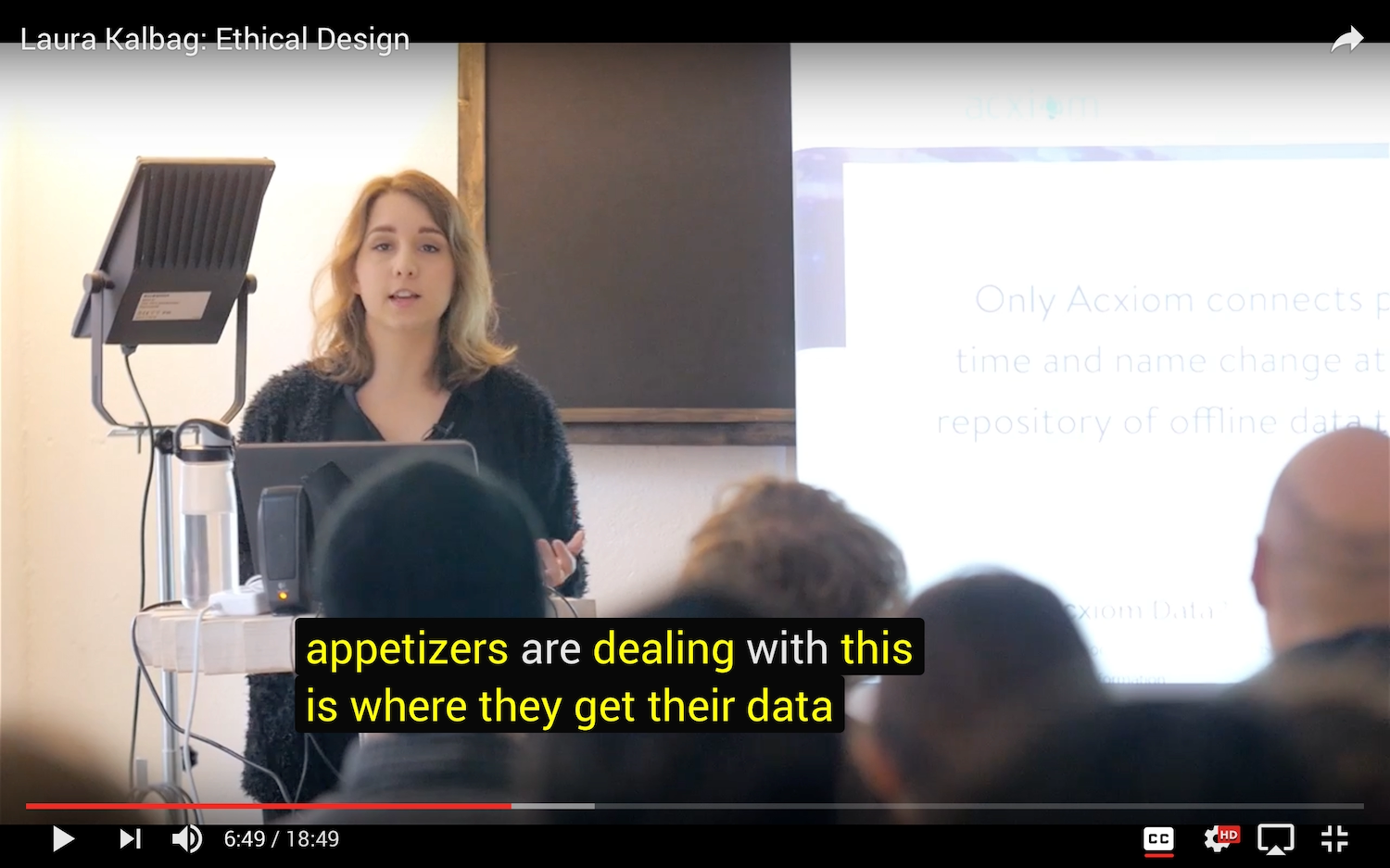 A YouTube video showing Laura speaking at a podium with the caption appetizers are dealing with this is where they get their data.